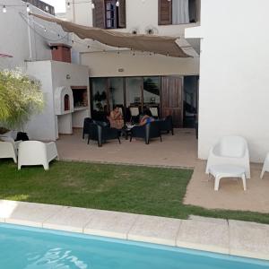 eine Terrasse mit Stühlen und einem Pool in einem Haus in der Unterkunft Güemes Hostel Cordoba in Cordoba