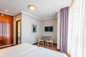 Schlafzimmer mit einem Bett, einem Tisch und Stühlen in der Unterkunft Hotel Verdemar in Ribadesella
