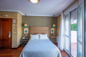 ein Schlafzimmer mit einem großen Bett und einem großen Fenster in der Unterkunft Hotel Verdemar in Ribadesella