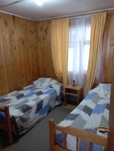 a bedroom with two beds and a window at Cabañas Ancud Magico in Ancud