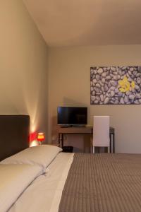 a bedroom with a bed and a desk and a television at Residence Nazionale Matera in Matera