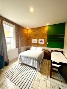 a bedroom with two beds and a green wall at HMG Morada & Chalet - Centro histórico in Petrópolis