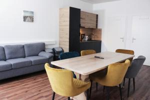 una mesa y sillas en una sala de estar con sofá en Hive Apartments - direkt an der Hannover Messe, en Hannover