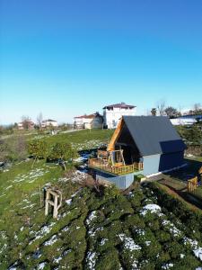 a small house with a deck on a field at Luna Bungalov in Rize