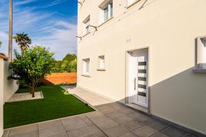 Casa blanca con patio con césped en Pensión Casa Alvarito en Portonovo