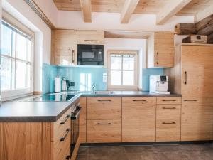 a kitchen with wooden cabinets and a counter top at Haus 1683 - Wolfbauer in Johnsbach