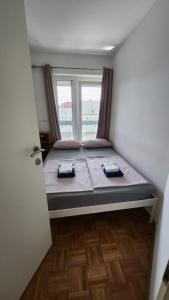 Bett in einem Zimmer mit Fenster in der Unterkunft Apartment Hanna in Koper