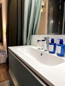 a bathroom sink with two bottles of soap and a mirror at EZE Roc Monaco & Concierge in Éze +44 photos