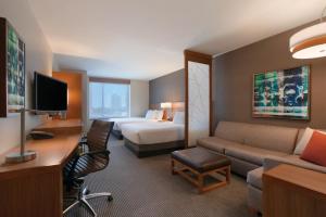 a hotel room with a bed and a couch and a desk at Hyatt Place Chicago-South/University Medical Center in Chicago