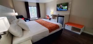 a hotel room with a bed and a television at THE PARAGON of Golden Isles in Brunswick