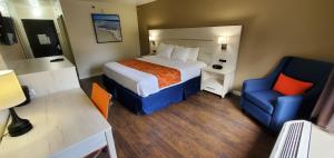 布倫瑞克的住宿－THE PARAGON of Golden Isles，酒店客房,配有一张床和一张蓝色椅子