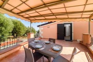 a patio with a table and chairs on a deck at Casa Vacanze Maraldo in Marina di Camerota