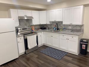 uma cozinha com armários brancos e um frigorífico branco em Sweet bedroom located central of downtown em Baltimore