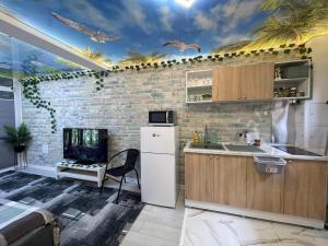 a kitchen with a white refrigerator and a brick wall at Studio in Panoramic House in Cluj-Napoca