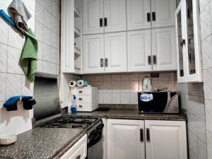 una cucina con armadietti bianchi e forno a microonde di Dokki private home with 2 rooms WiFi Air-conditioning a Il Cairo