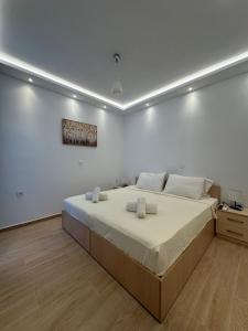 a white bedroom with a large bed with white walls at Hella apartment in Rhodes Town
