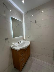 a white bathroom with a sink and a mirror at Hella apartment in Rhodes Town