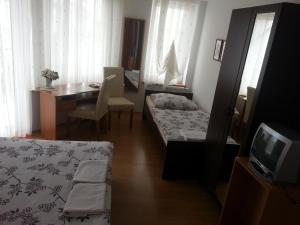 a room with two beds and a desk and a tv at Villa Osowianka in Gdańsk