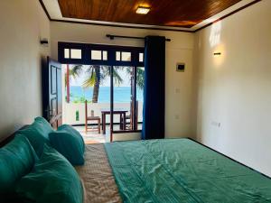 a bedroom with a bed with a view of the ocean at Blue Surf View - Tangalle in Tangalle