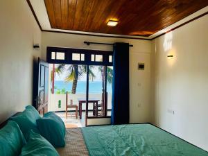 a bedroom with a bed with a view of the ocean at Blue Surf View - Tangalle in Tangalle