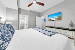 a bedroom with a white bed and a ceiling fan at Gulf Dunes 506 Hello Sunshine in Fort Walton Beach