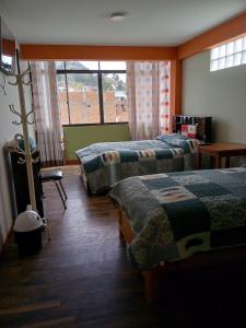 a hotel room with three beds and a window at Jhonyximena in Copacabana