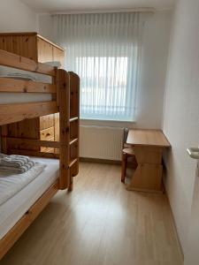 a room with two bunk beds and a table at Ferienhaus Brandes Wohnung 2 in Norderney
