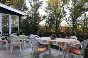 un patio con sillas blancas y mesas con flores. en Sopron Balf Panzio, en Sopron