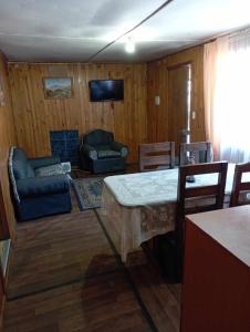uma sala de estar com uma mesa e cadeiras e um sofá em Cabañas Ancud Magico em Ancud