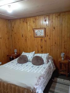 a bedroom with a bed with two pillows on it at Cabañas Ancud Magico in Ancud