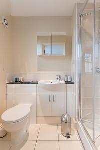 uma casa de banho branca com um WC e um lavatório em Camstay Abbey Street em Cambridge