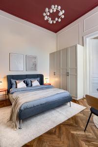a bedroom with a blue bed and a chandelier at City Center Art Apartment in Arad