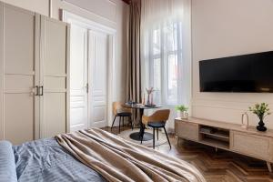 1 dormitorio con 1 cama, TV y mesa en City Center Art Apartment, en Arad