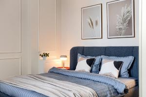 a bedroom with a blue bed with two pillows at City Center Art Apartment in Arad