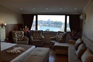イスタンブールにあるブルー イスタンブール ホテル タクシムのリビングルーム(ソファ、椅子、大きな窓付)