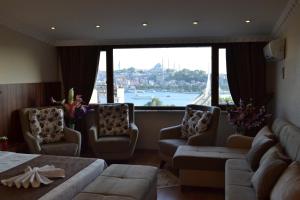 a living room with a couch and chairs and a large window at Blue Istanbul Hotel Taksim in Istanbul