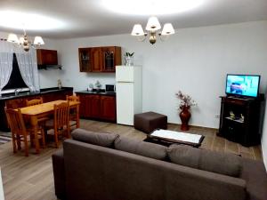 a living room and kitchen with a couch and a table at Casa Jardim in Ponta do Pargo