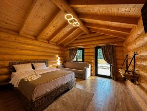 ein Schlafzimmer mit einem Bett in einer Blockhütte in der Unterkunft Hanul și Păstrăvăria Țibău in Cîrlibaba
