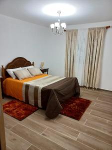 a bedroom with a large bed with rugs on the floor at Casa Jardim in Ponta do Pargo