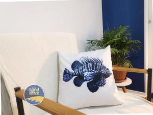 a pillow with a fish on it sitting on a chair at Studio Sand & Blue Copacabana Beach in Rio de Janeiro