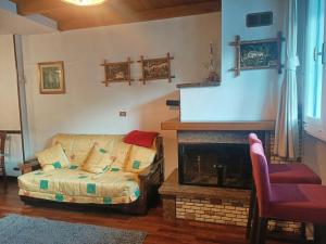 ein Wohnzimmer mit einem Sofa und einem Kamin in der Unterkunft Monte Miletto Apartment in San Massimo