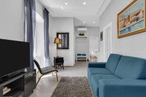 salon z niebieską kanapą i telewizorem w obiekcie City Center Apartment Dvor Kalalarga w Makarskiej