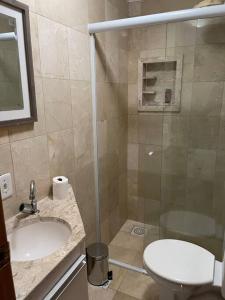 uma casa de banho com um chuveiro, um WC e um lavatório. em Apto mobiliado, 50 metros da praia. em Angra dos Reis