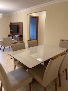 uma sala de jantar com uma mesa branca e cadeiras em Apto mobiliado, 50 metros da praia. em Angra dos Reis