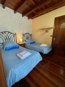 聖地亞哥－德孔波斯特拉的住宿－Casa de Costoia，一间卧室设有两张床和一扇门