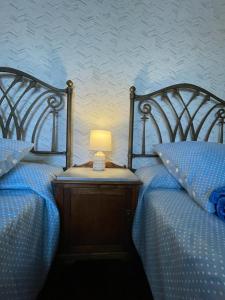 two beds with a lamp on a wooden night stand at Casa de Costoia in Santiago de Compostela