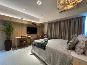 Studio de Luxo com vista deslumbrante para o Rio في ماناوس: غرفة نوم بسرير ومكتب وتلفزيون
