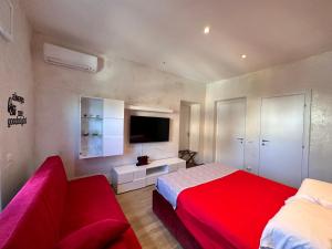 a bedroom with a red bed and a couch at Othalan Home in Paestum