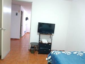a bedroom with a television and a tiled floor at duplicado in Tlacote el Bajo