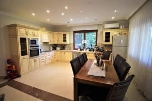 cocina grande con mesa de madera y sillas en Kukukk-fészek, en Mogyoród